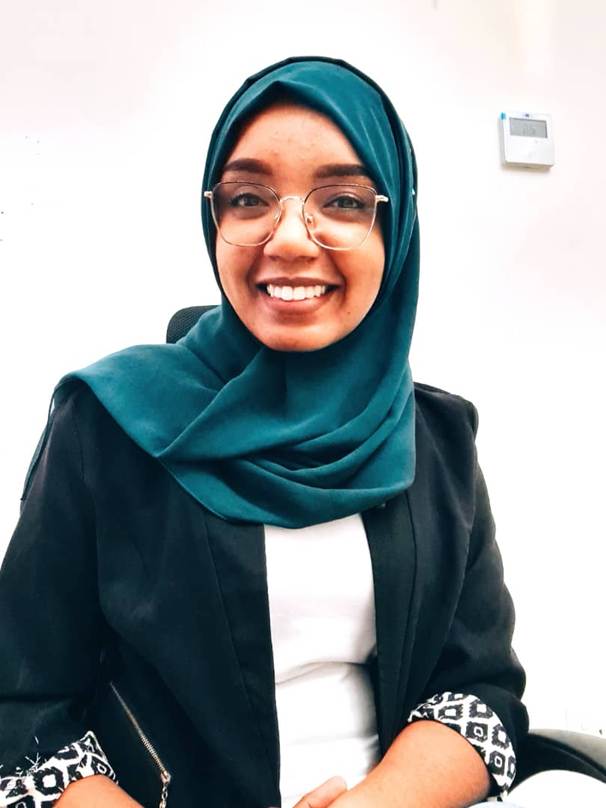 A person wearing a head scarf and glasses

Description automatically generated